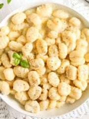gnocchi with gorgonzola sauce topped with pepper and basil in a small bowl.