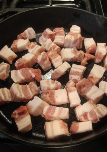 raw pork belly cubes just added to the skillet.