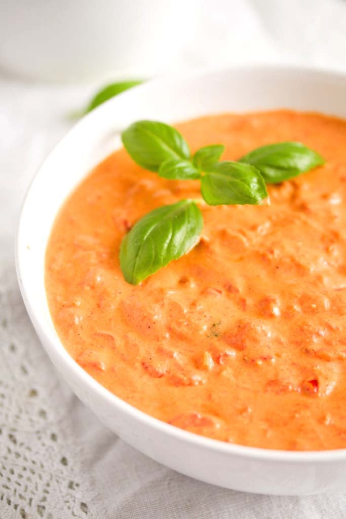 mascarpone and tomato sauce in a white bowl with basil.