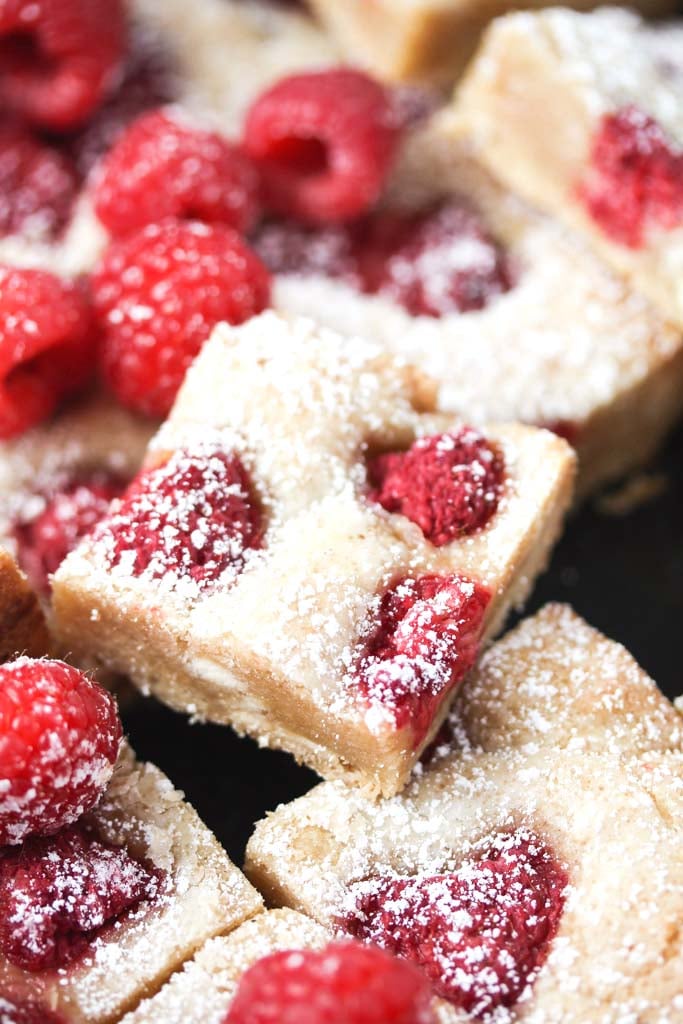 stapled cake dusted with icing sugar with berries around it.