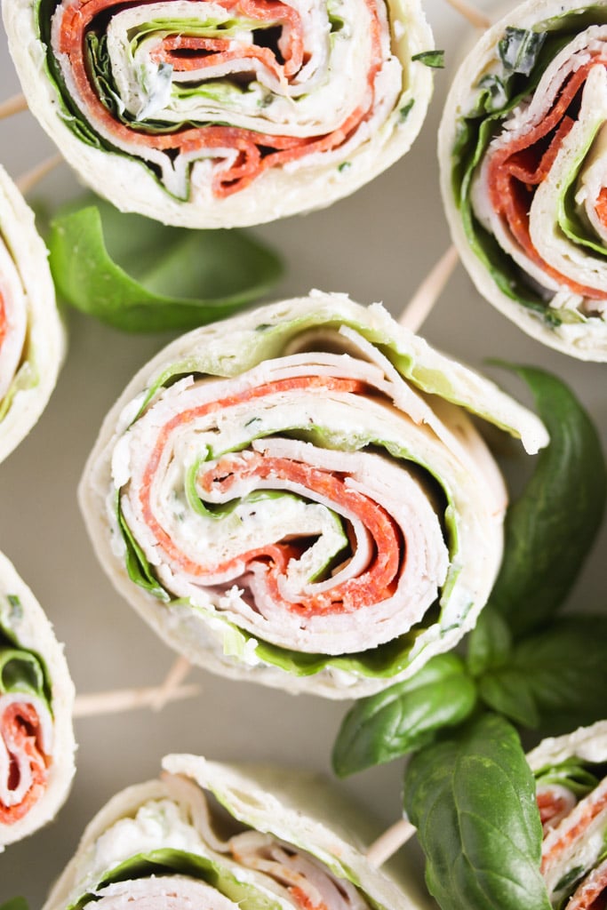 several italian tortilla roll ups showing the filling of pepperoni and lettuce.