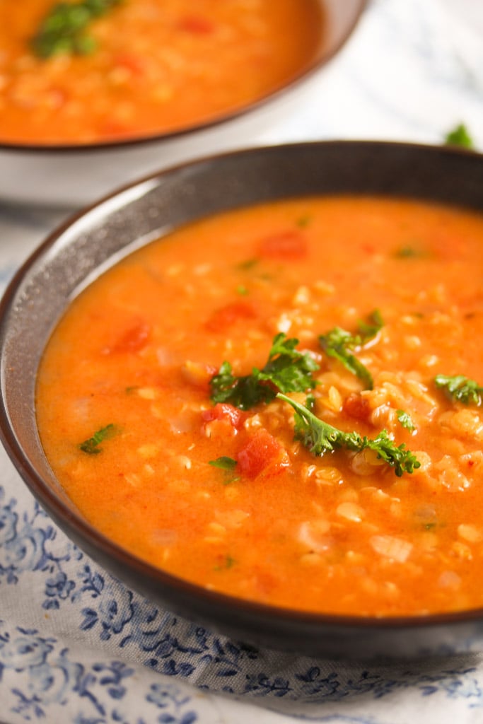 close up of middle eastern soup with pulses and tomatoes.