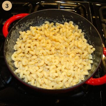 mixing macaroni and cheese sauce made without flour in a dutch oven on the stove top.