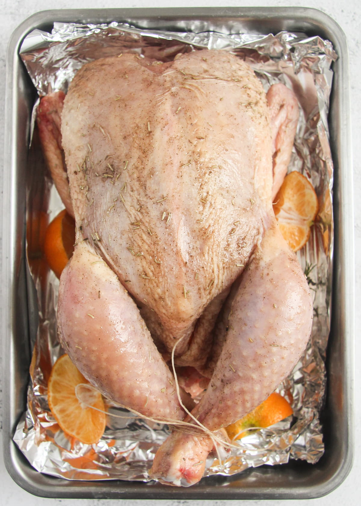 uncooked whole chicken in a roasting tin.