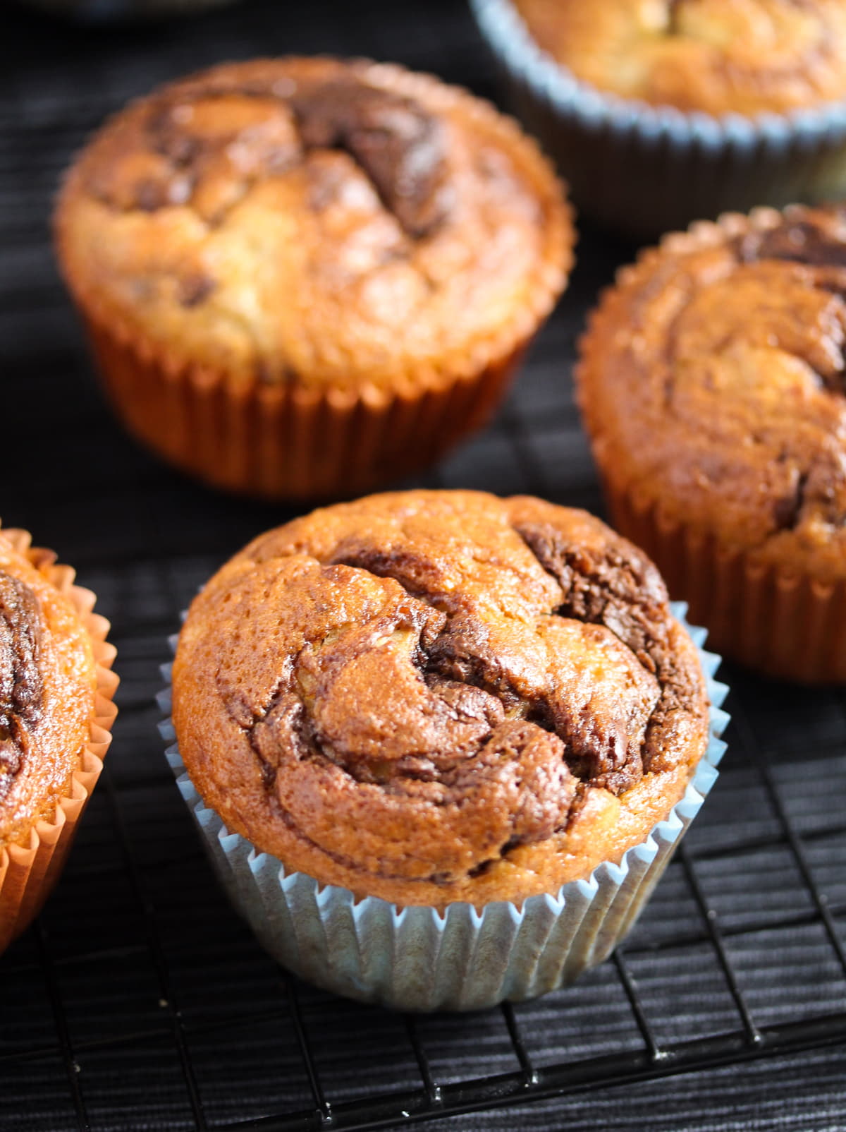 several brown muffins with bananas and nutella.