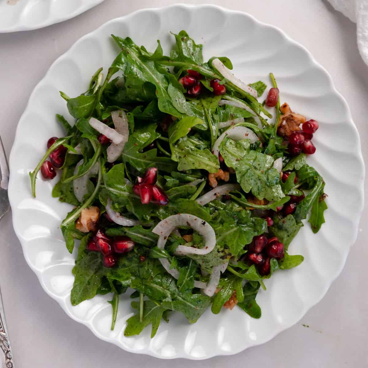 plate of rocket salad with pomegranate seeds.