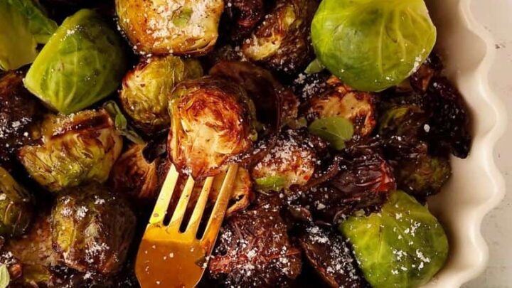golden brown air fryer brussels sprouts in a white dish.