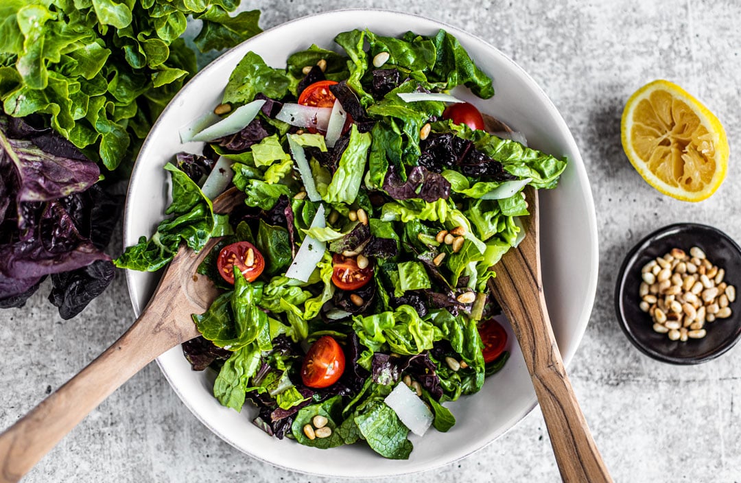 bowl of green salad with tomatoes.