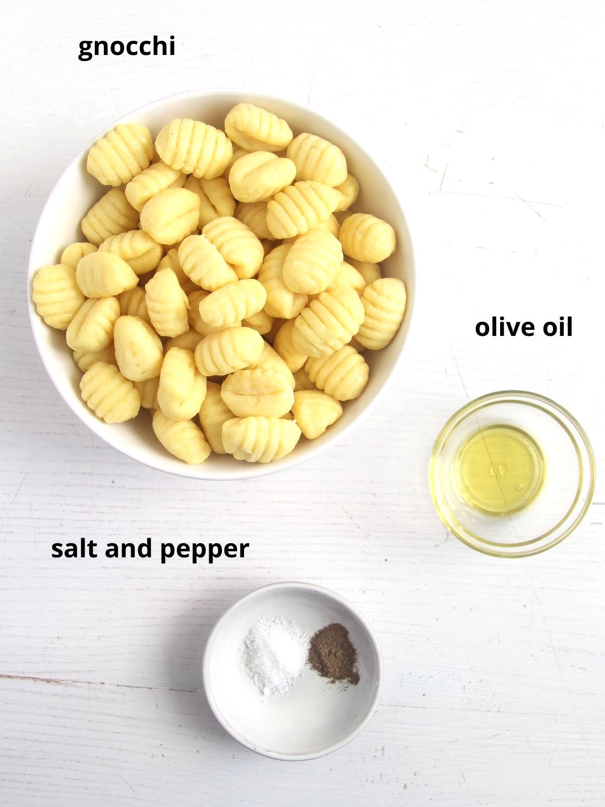 bowls of uncooked gnocchi, oil, salt and pepper on the table.