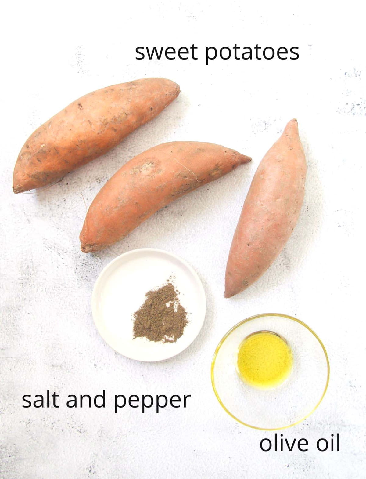 three whole sweet potatoes, bowl with oil and bowl with spices.