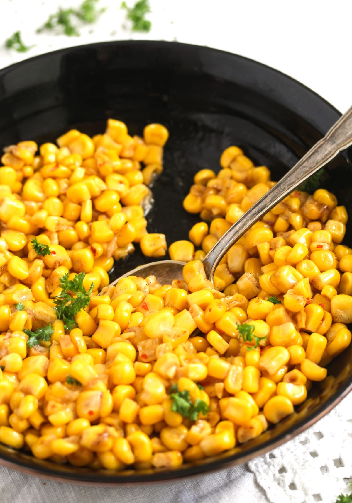serving cooked corn kernels with a spoon.
