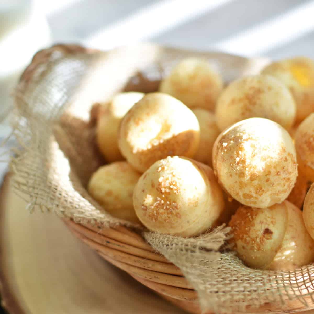 many balls of brazilian cheese bread in a basket.