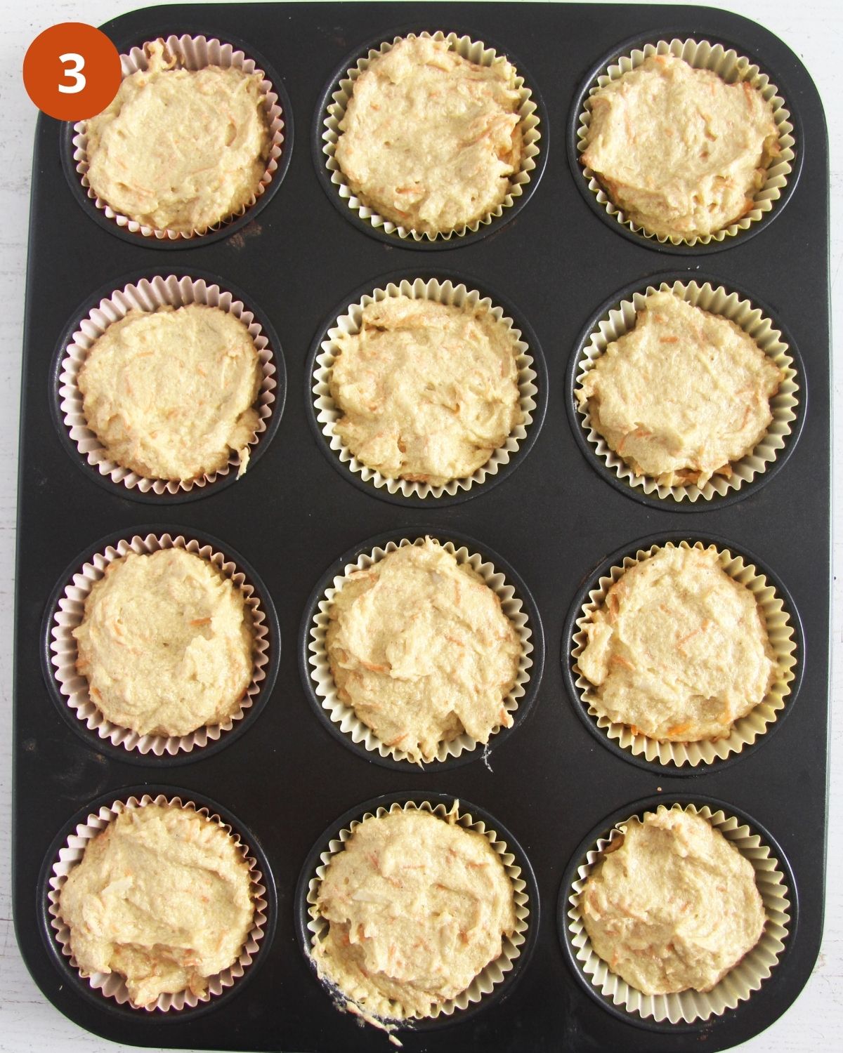 carrot and banana muffins in a muffin pan before baking.