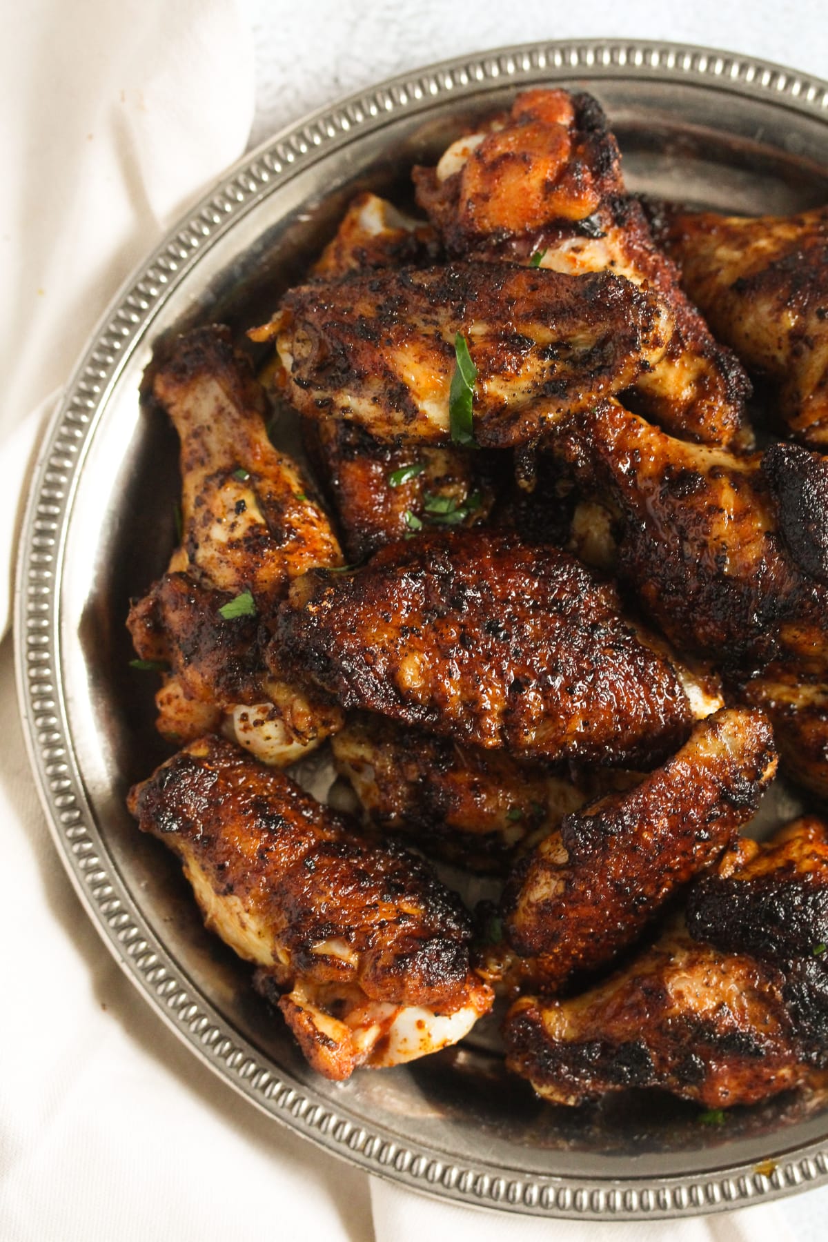 close up dark chicken wings spiced with dry rub seasoning.