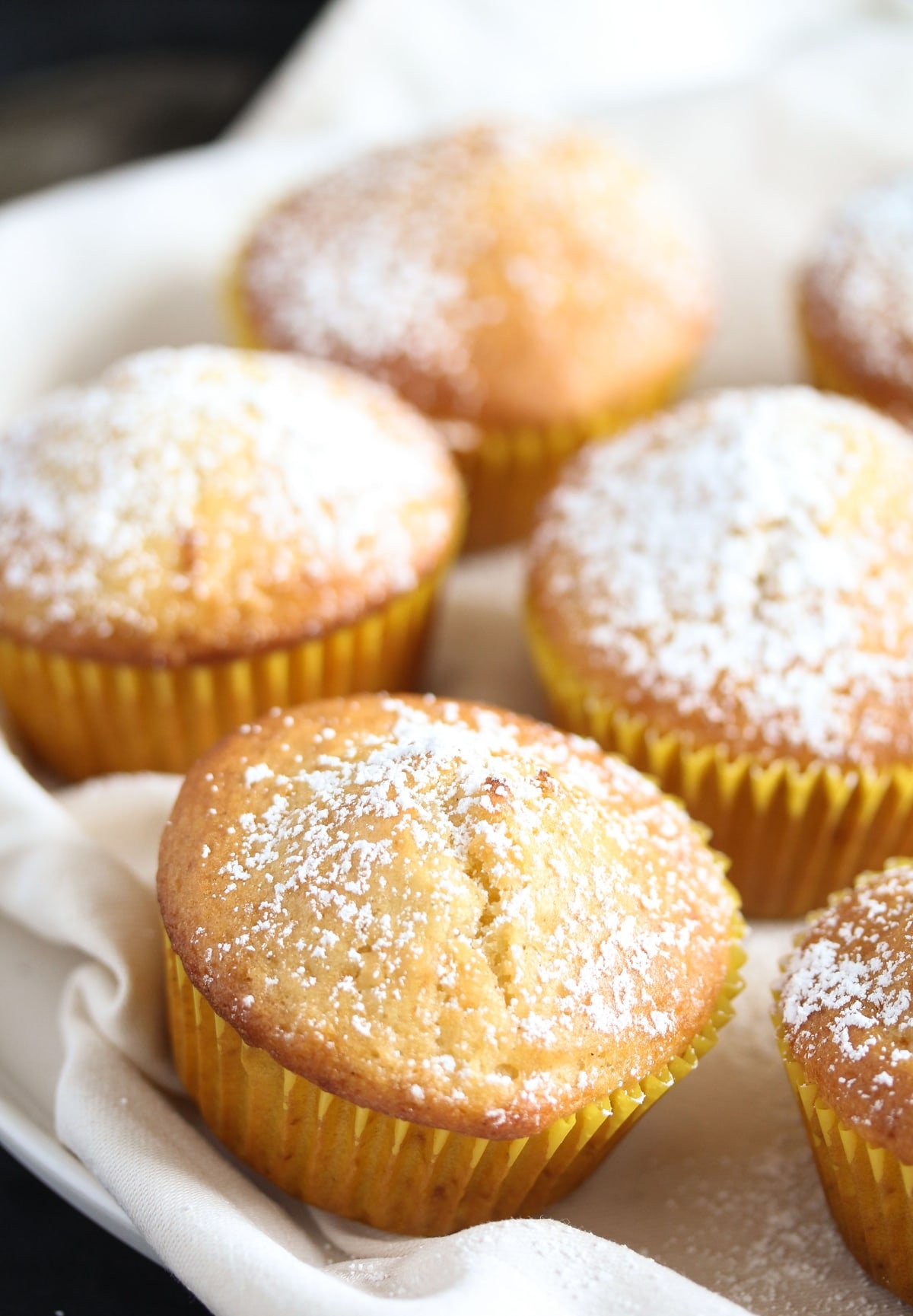 vanilla cupcakes on a white cloth close up.