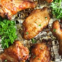 golden garlic butter chicken wings and fresh parsley on a wire rack.