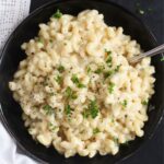 close up of a bowl with gouda mac and cheese sprinkled with parsley.