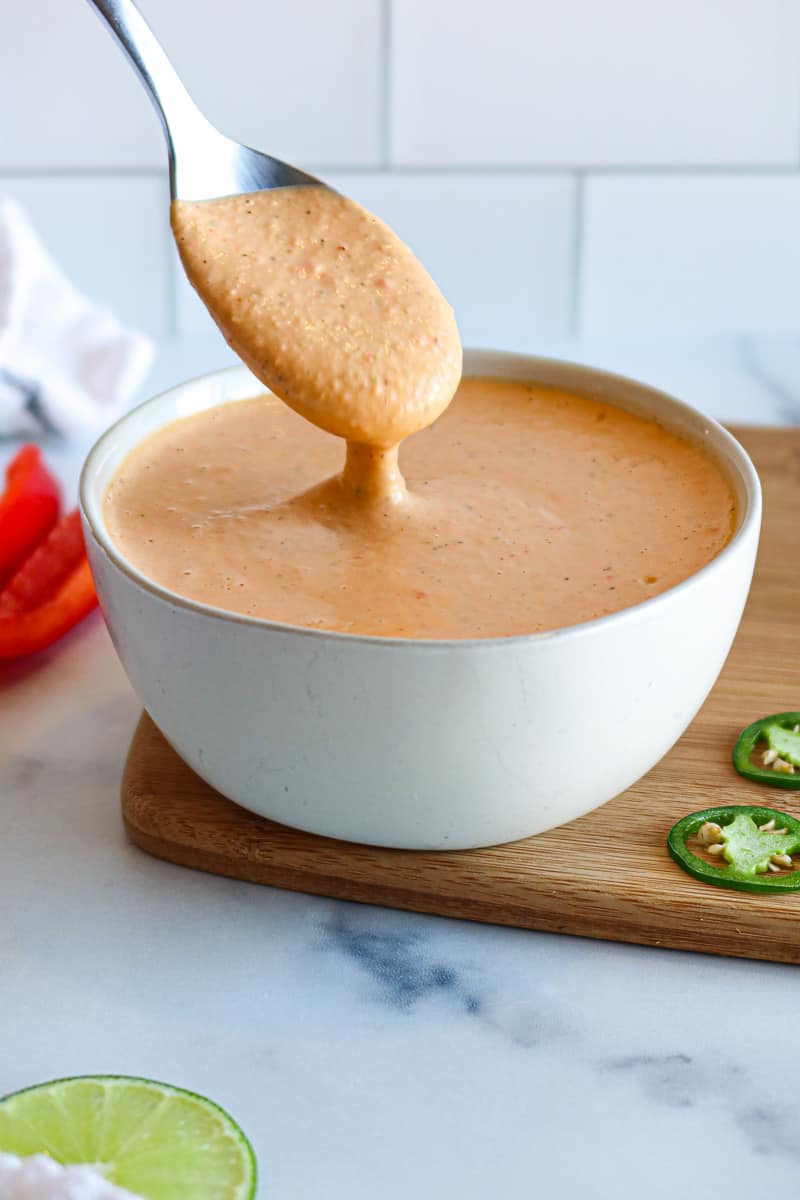 spoon lifting baja sauce from a small bowl.