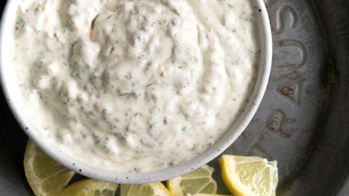 overhead view of bowl with tartar sauce and lemon slices.