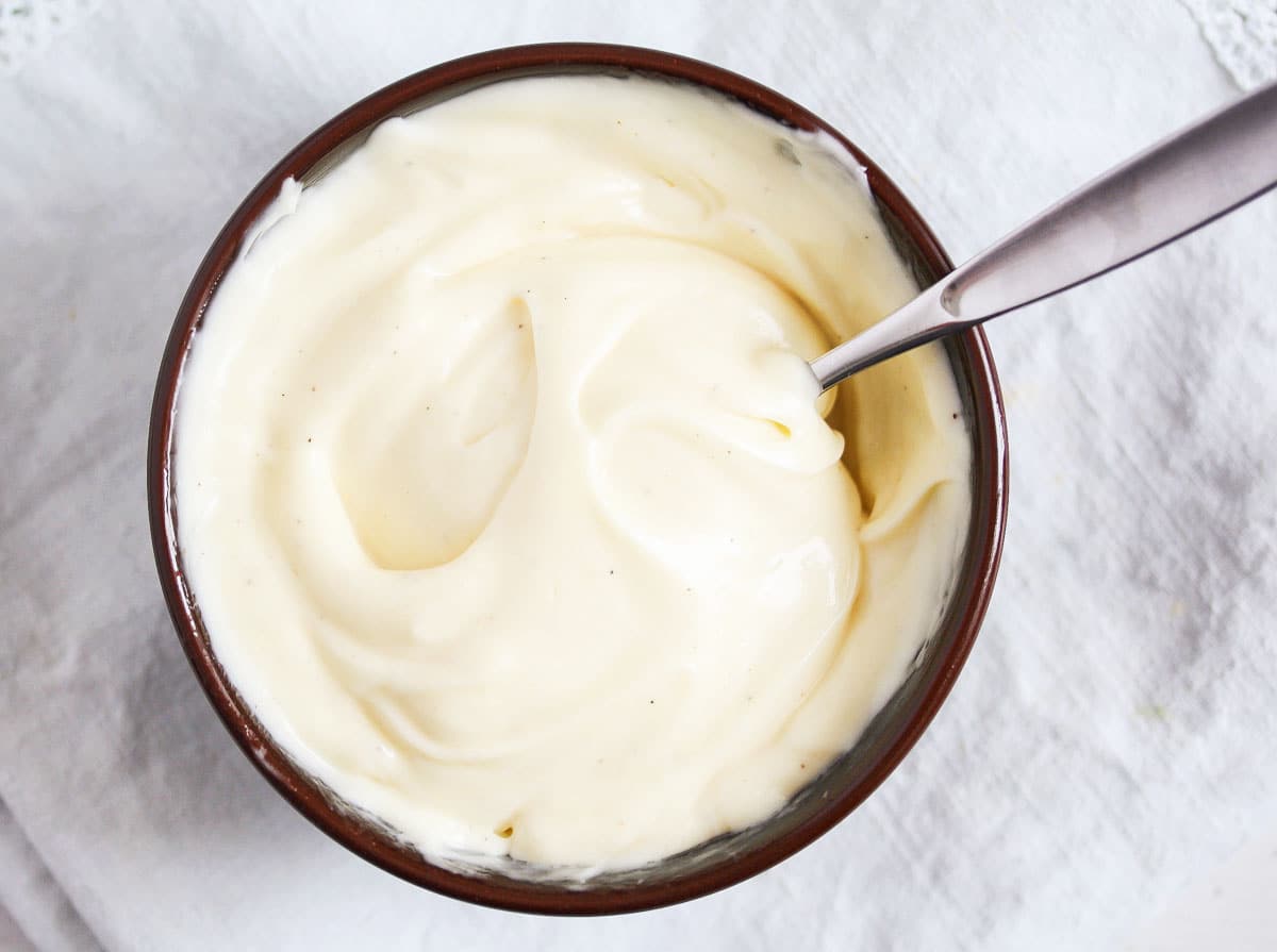 bowl of homemade mayonnaise with a spoon in it.