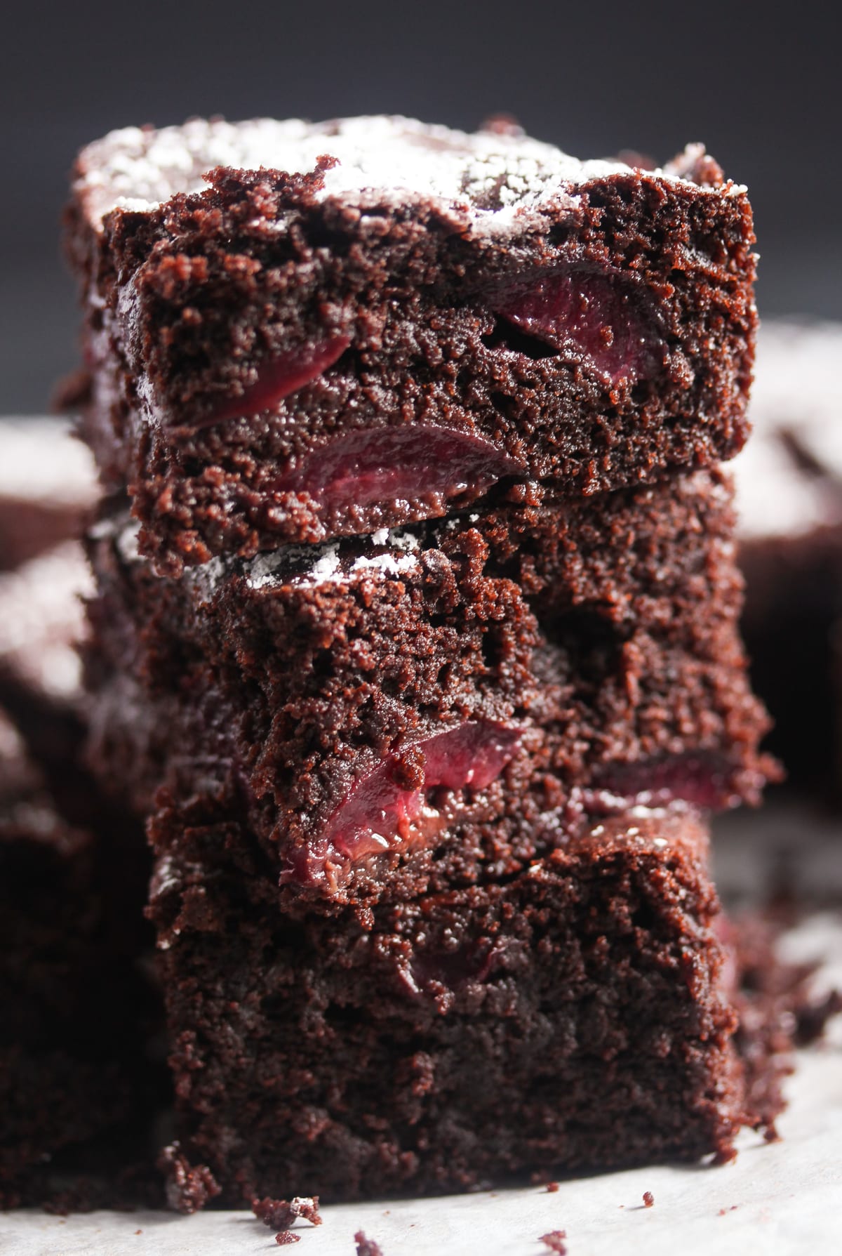 three chocolate cherry brownies stacked on the table.