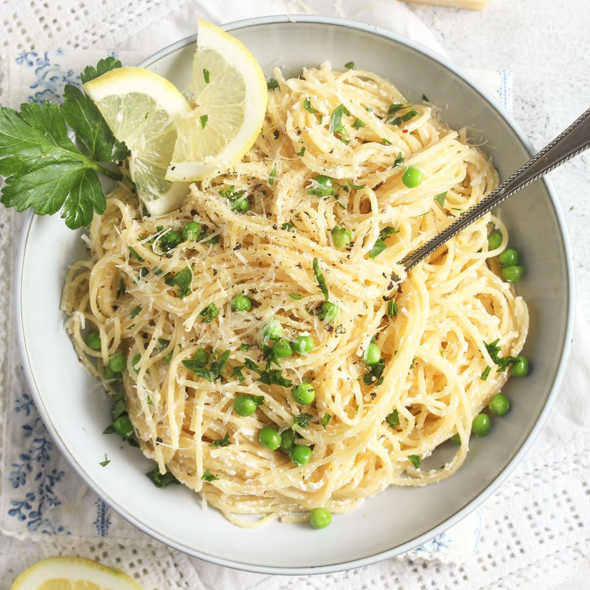 one pot pasta with ricotta and lemon in a bowl with lemon wedges and parsley.