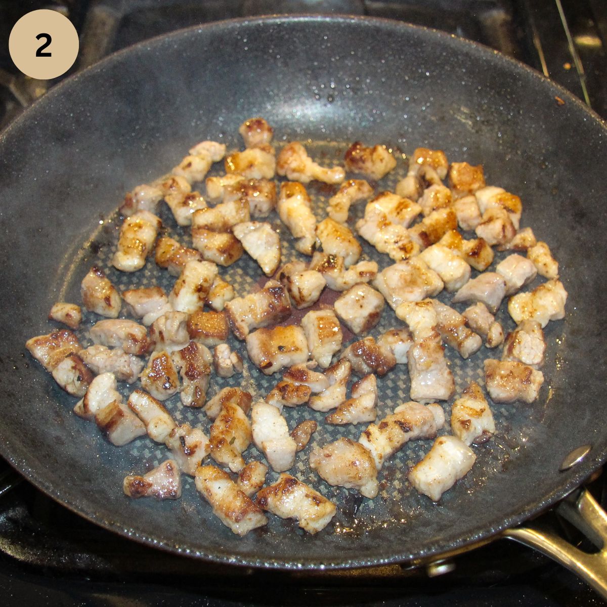 frying pork pieces in a frying pan.