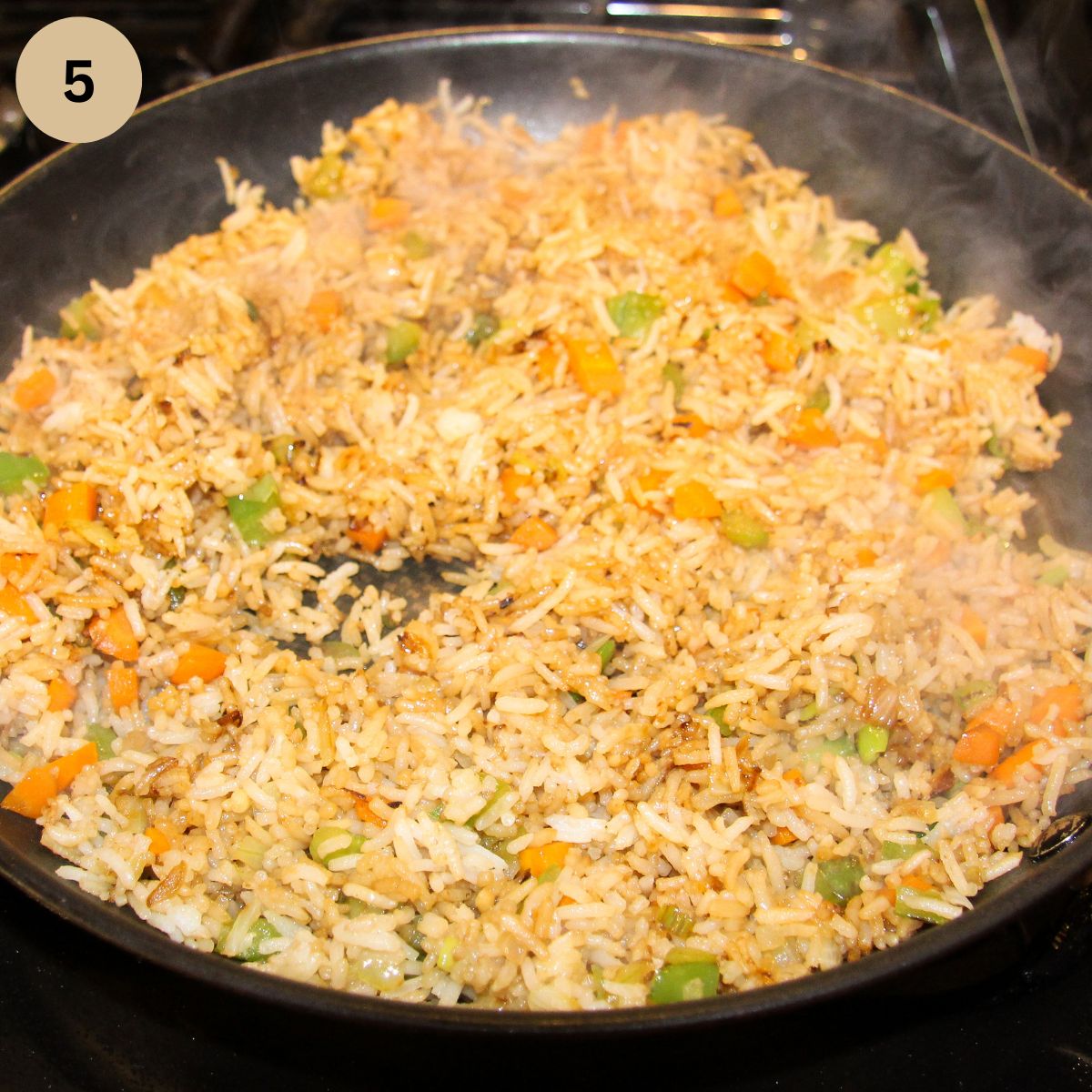frying rice and vegetables with soy sauce in a large pan.