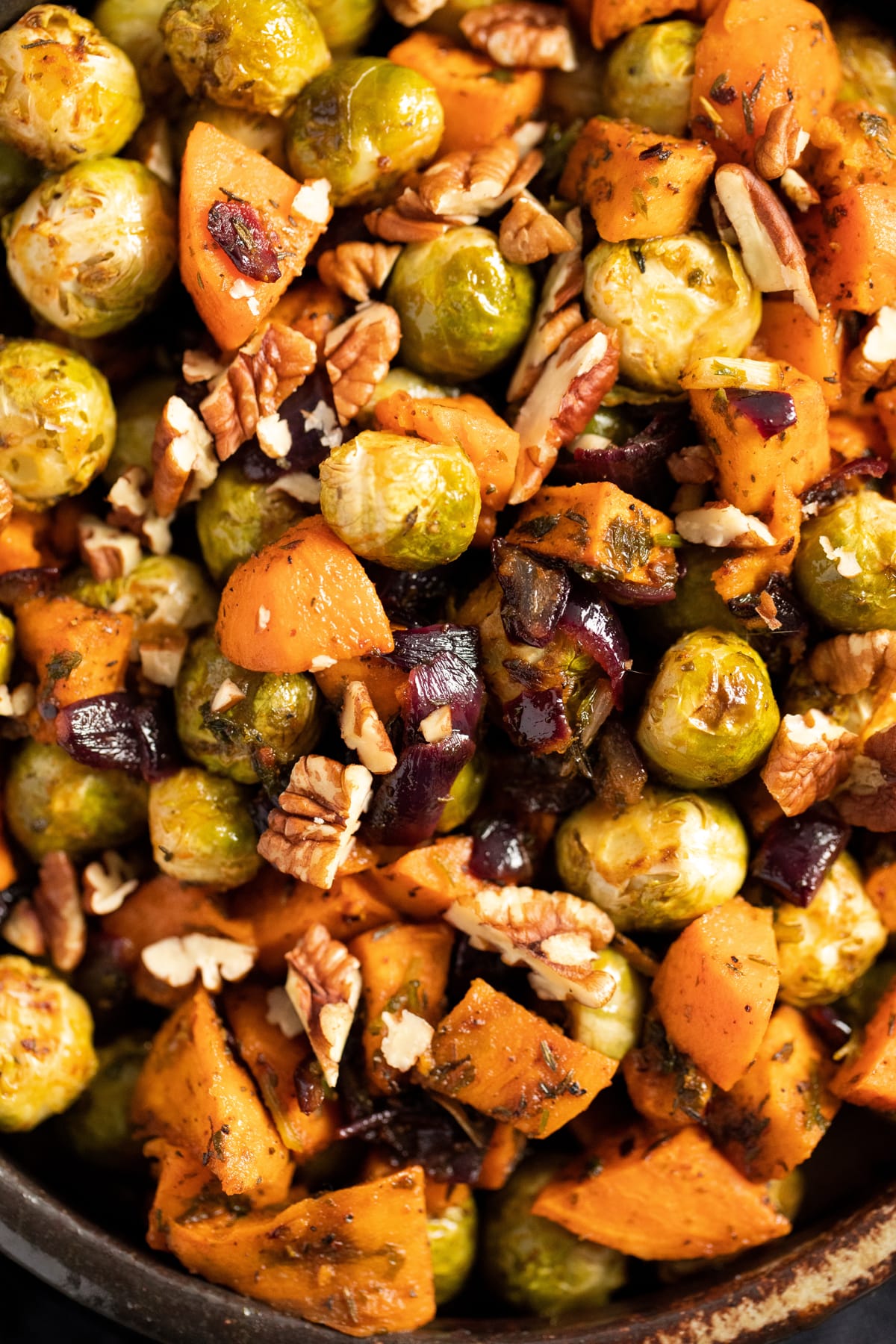 close up glossy vegetables and pecan nuts in a bowl.