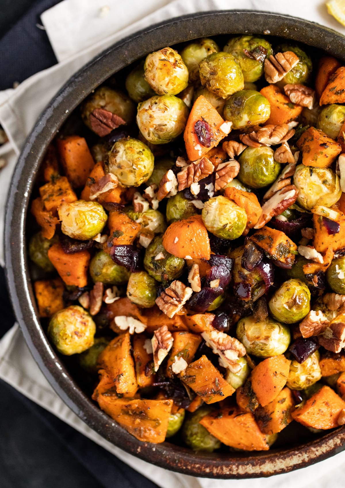 half a bowl with brussels sprouts and sweet potatoes roasted and glazed.