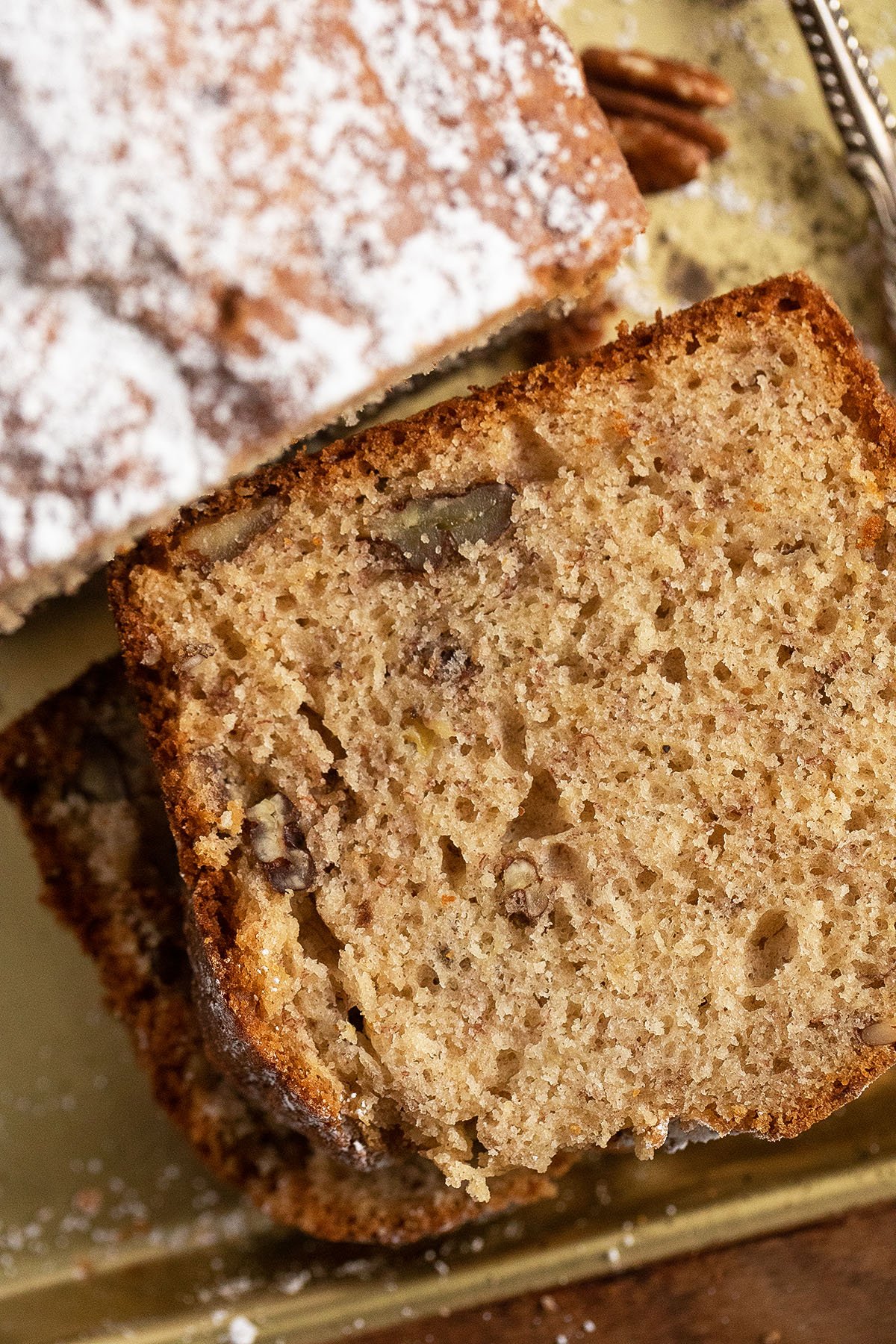 close up slices of moist banana bread without soda with pecans in it.