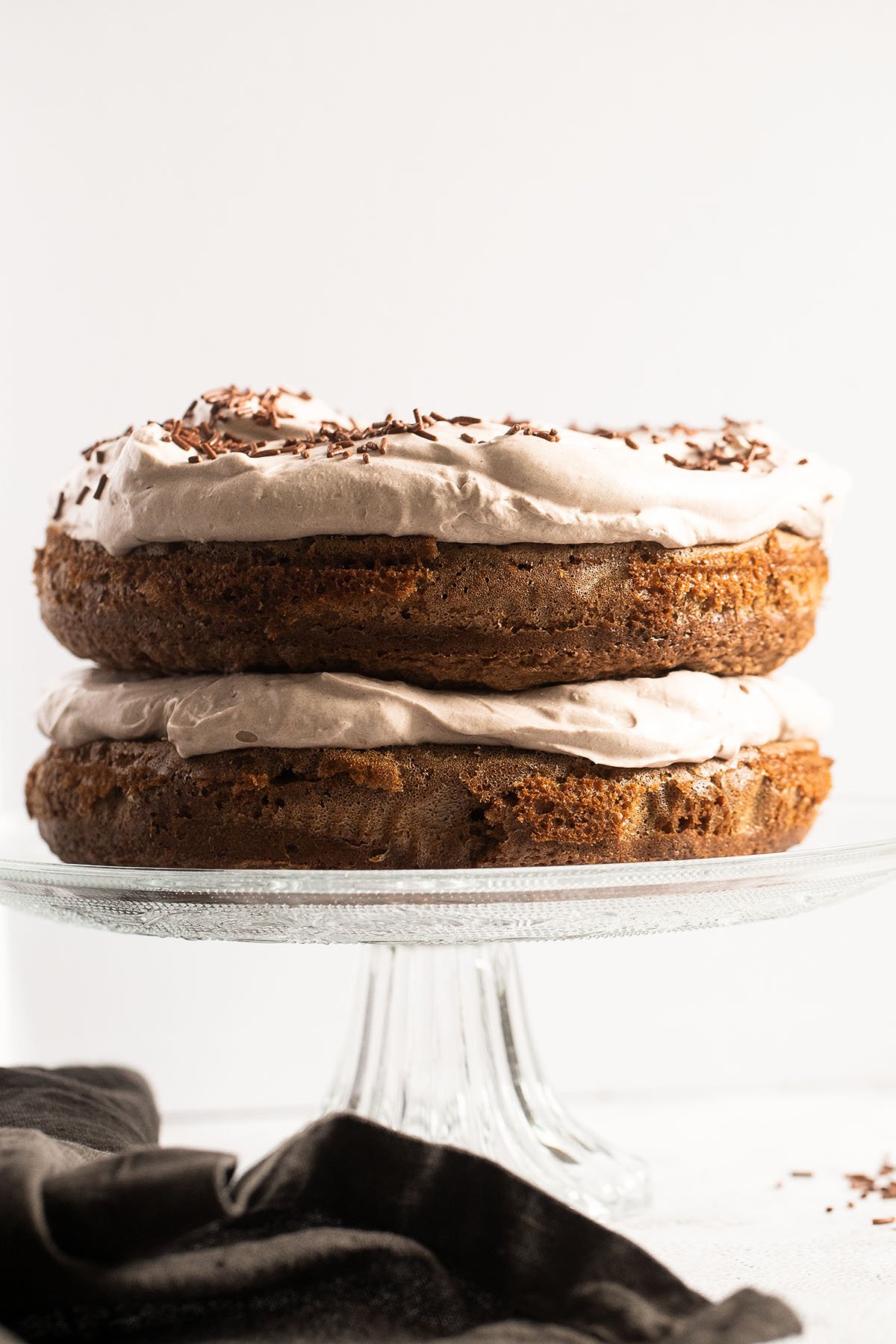 layered irish coffee cake on a tall platter with a brown towel underneath.