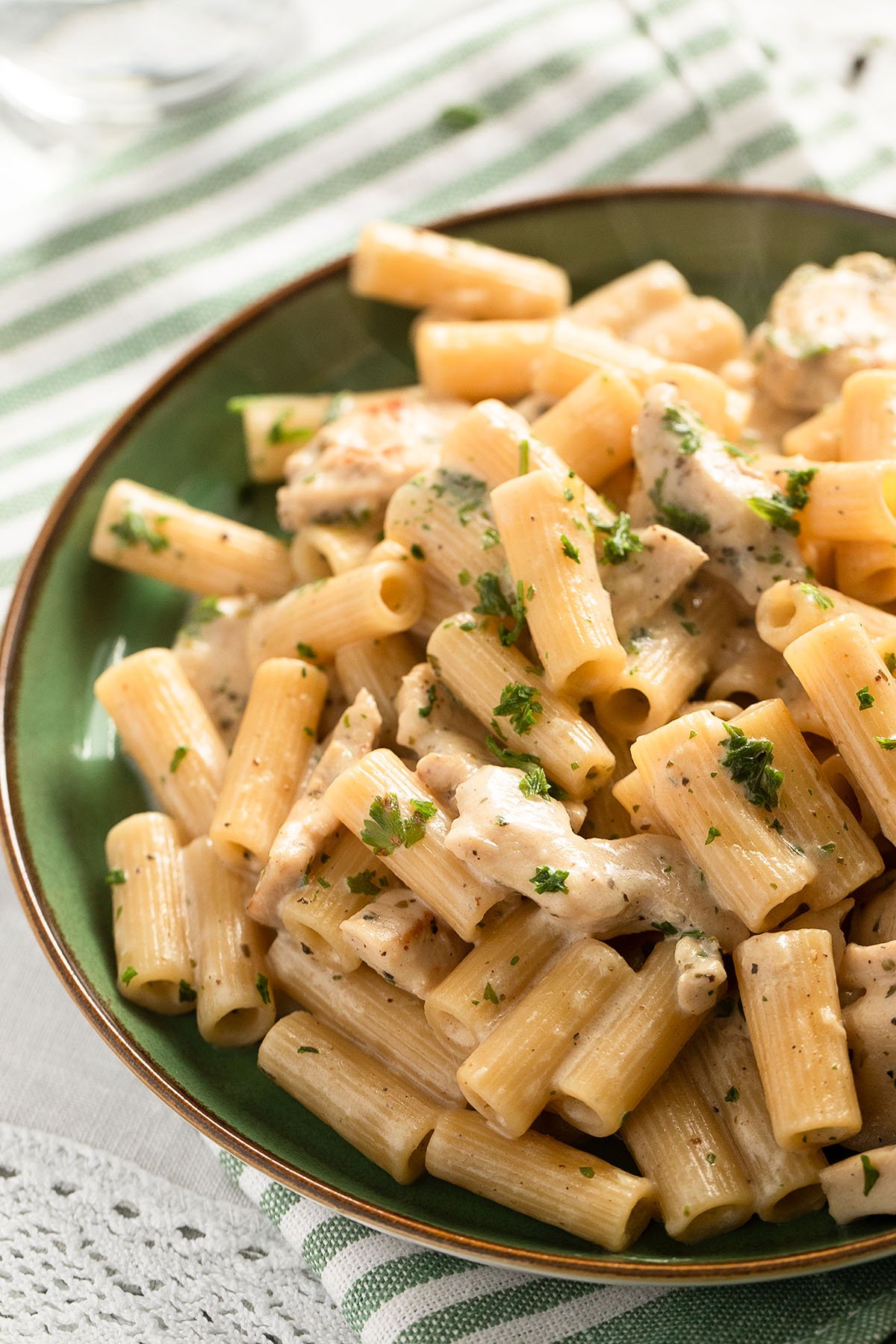 bowl of chicken pasta with parmesan, garlic and parsley.