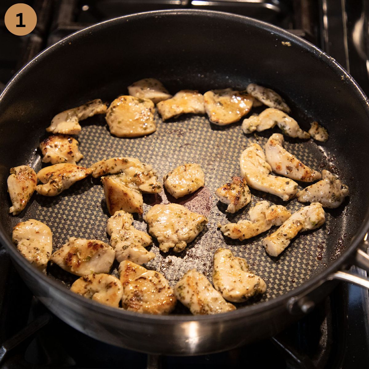 sauteing chicken breast pieces in a large skillet.