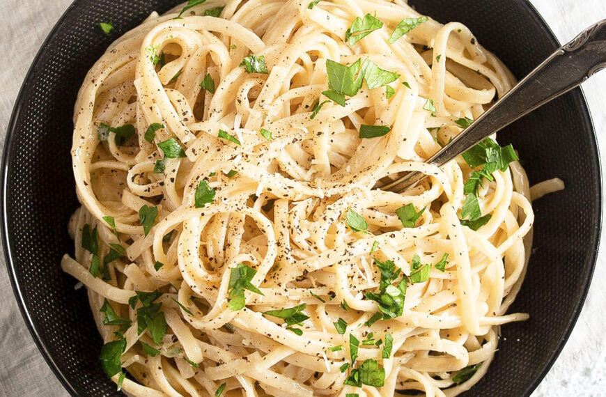 black bowl full of cream cheese pasta sprinkled with parsley.