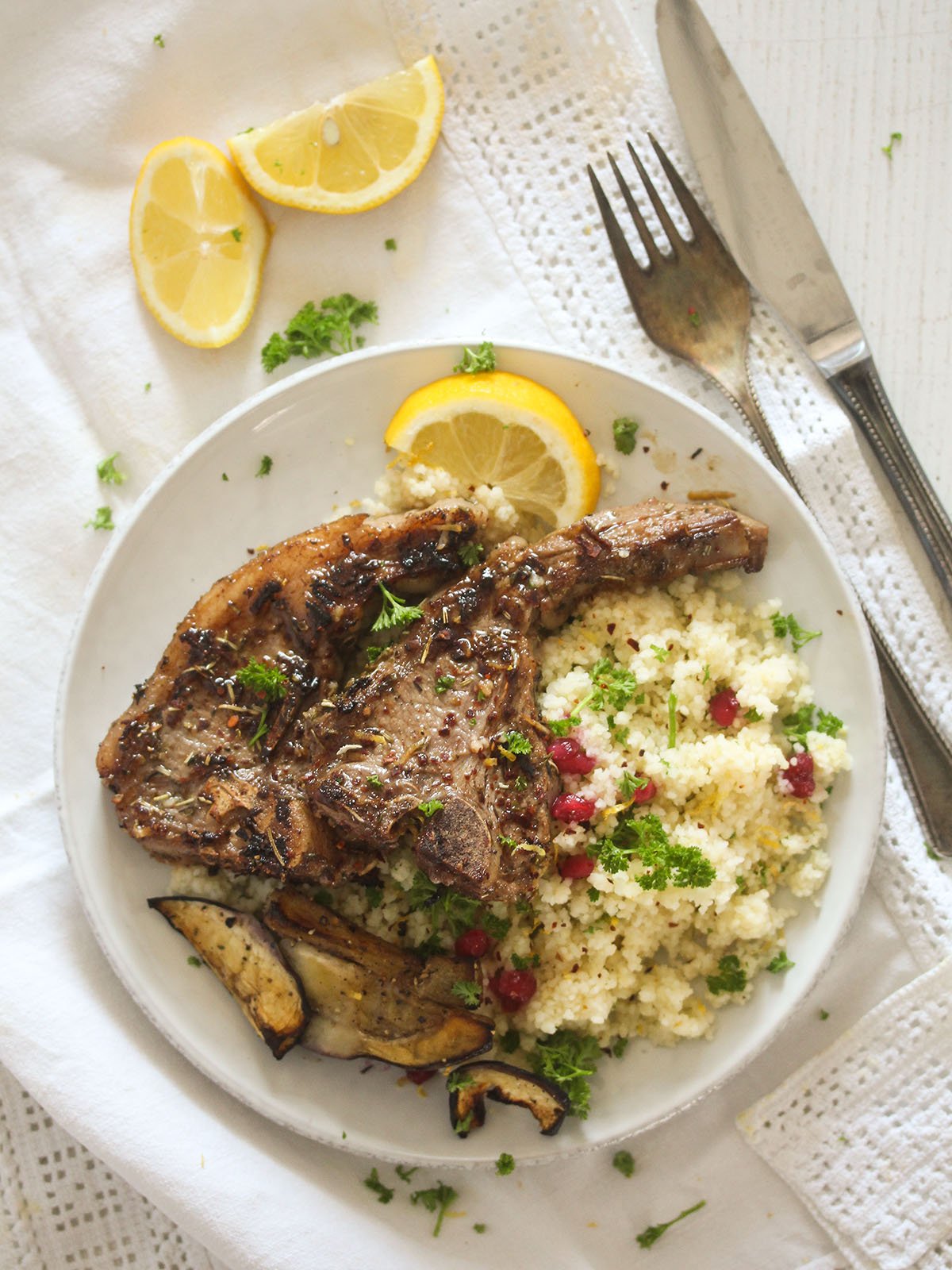 plate with turkish marinated lamb chops served with bulgur and lemon wedges.