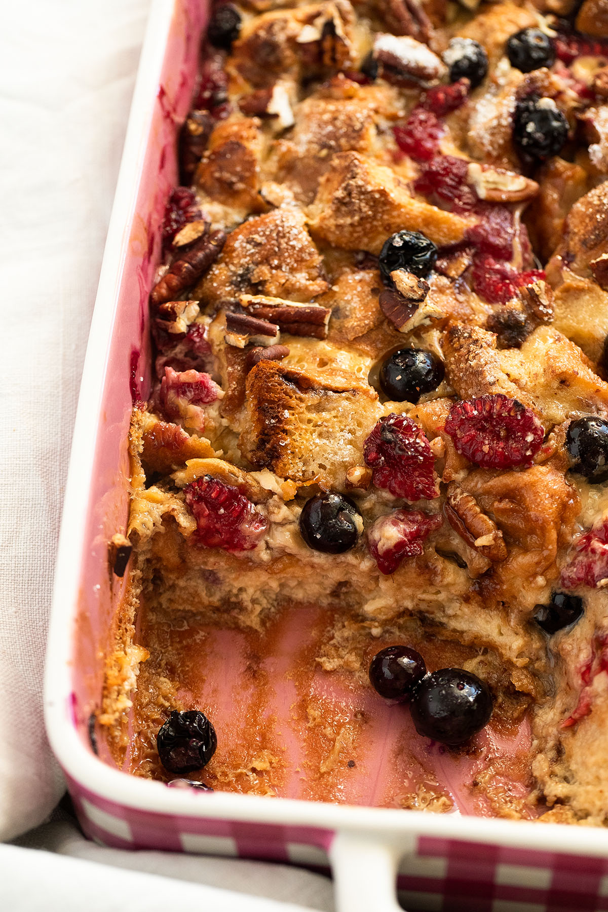 scooped french toast casserole with chocolate chip brioche bread and berries.