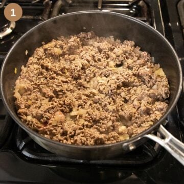 browning ground beef in a large saucepan on the stove.