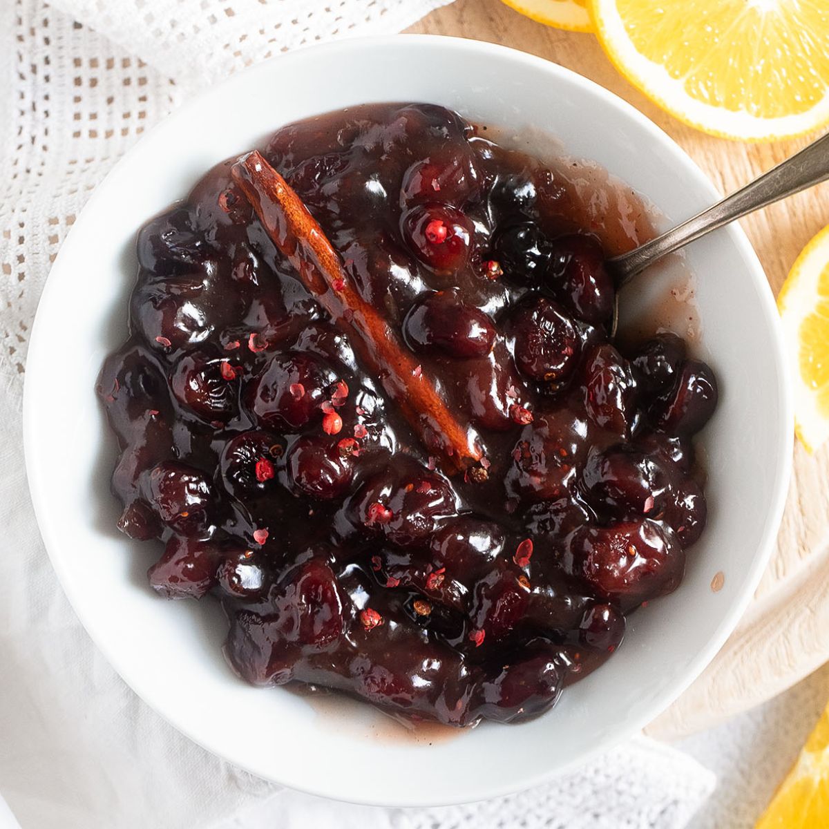 dried cranberry sauce from dried cranberries in a small bowl with a cinnamon stick in it.