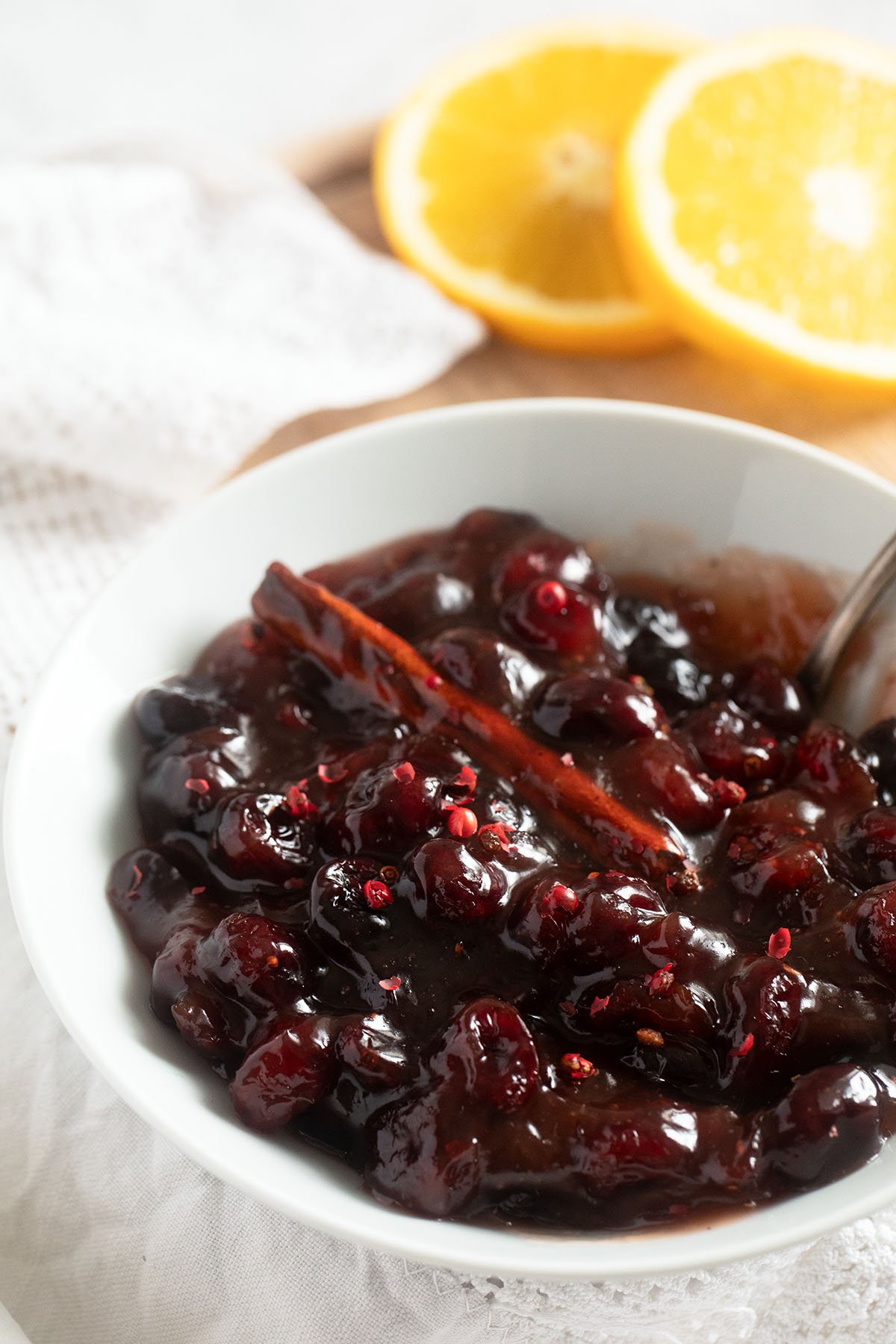 bowl of shiny sauce with dried cranberries and orange.