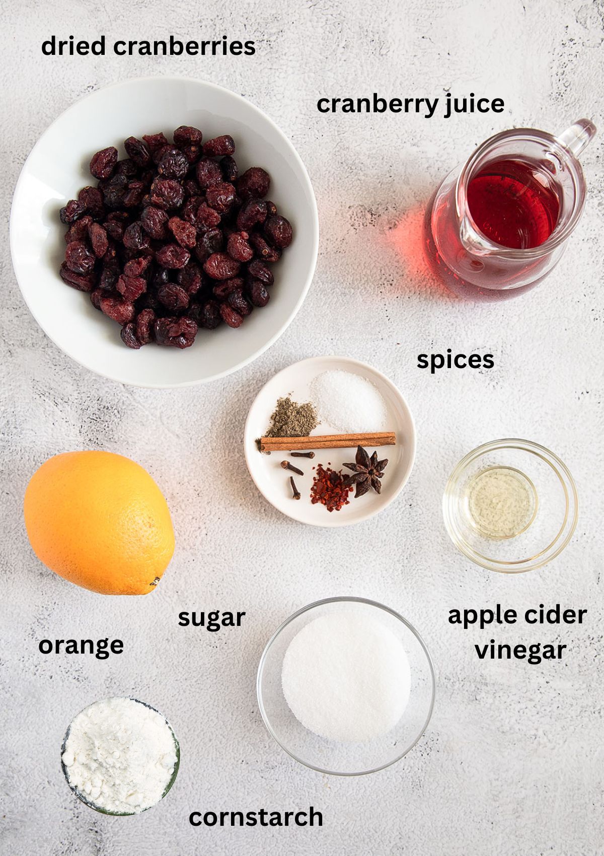 labeled ingredients for making dried cranberry sauce with orange, sugar and spices.