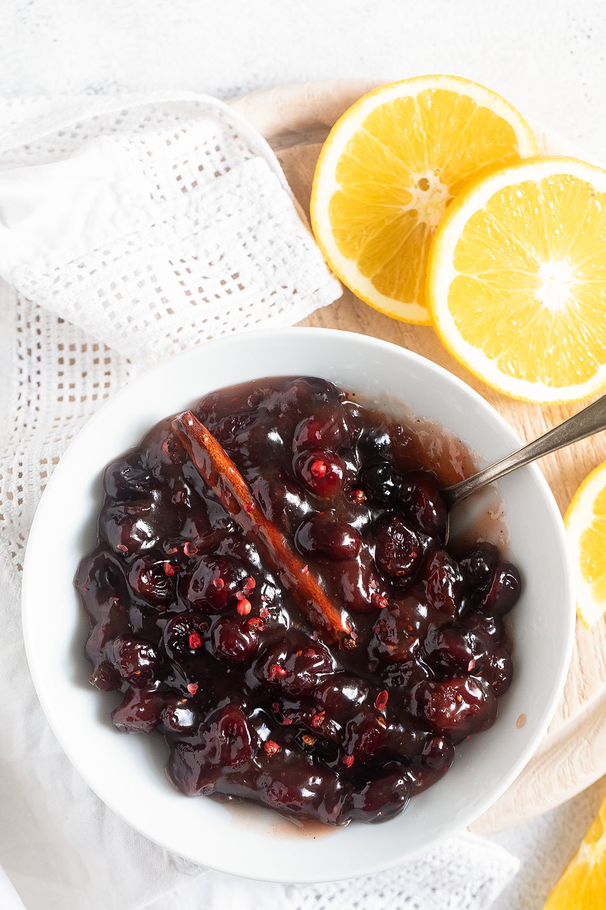 bowl of dried cranberry sauce and one orange cut in half.