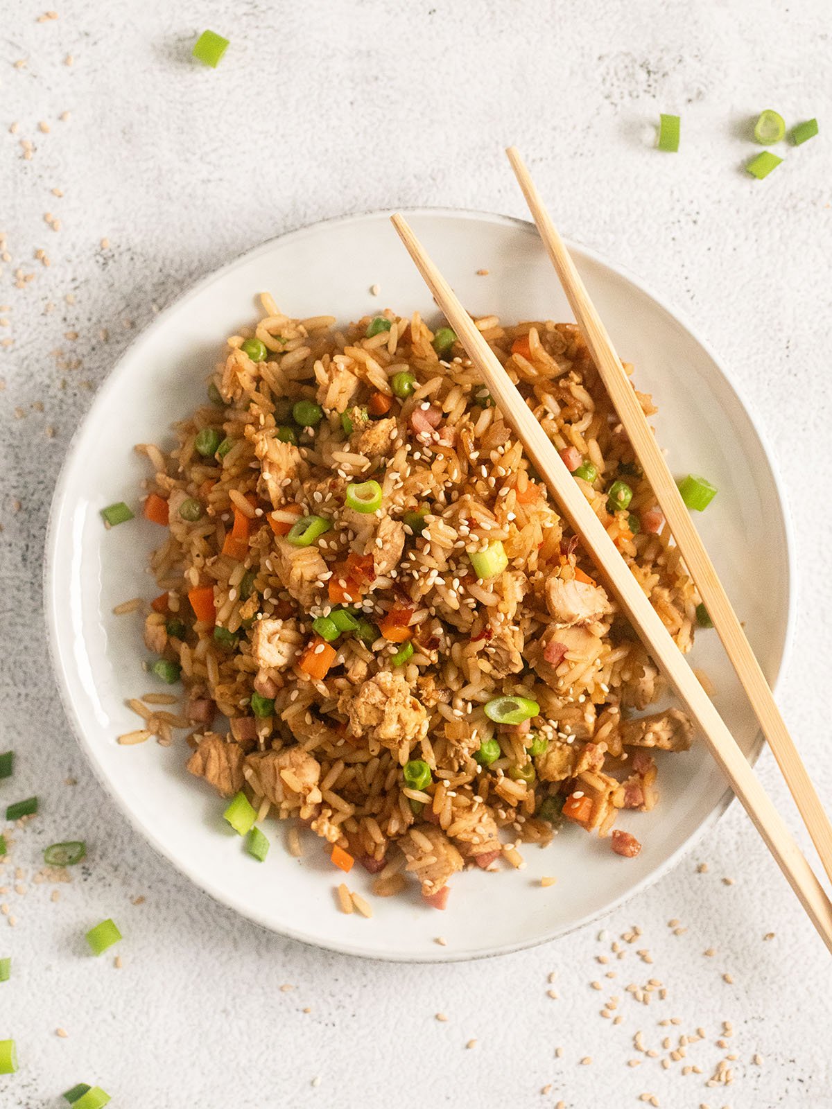 small plate with a mound of fried rice and two chopsticks.