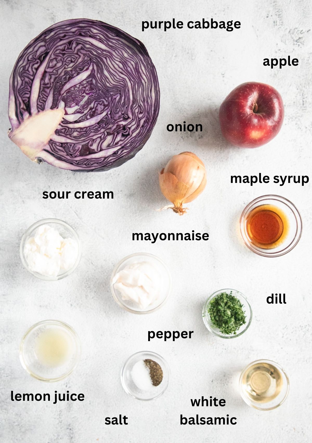 labeled ingredients for making slaw with purple cabbage, apple, onion, dill and sour cream.