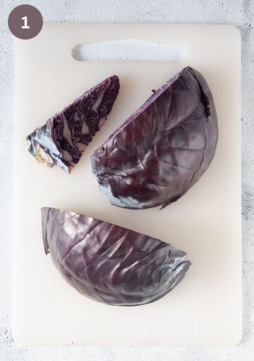 two quarters of a head of red cabbage and a piece of its removed core.
