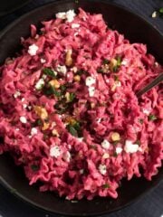 beetroot pasta topped with walnuts, feta and parsley.