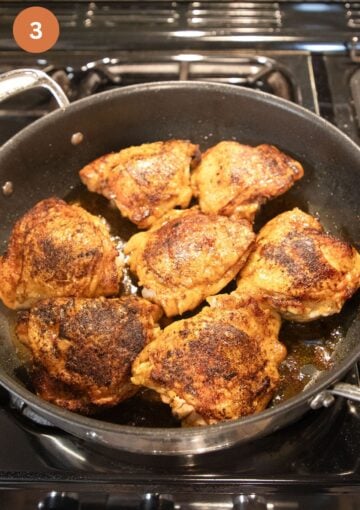 chicken thighs searing in a large pan.