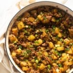 lamb and potatoes with peas in a large dutch oven.