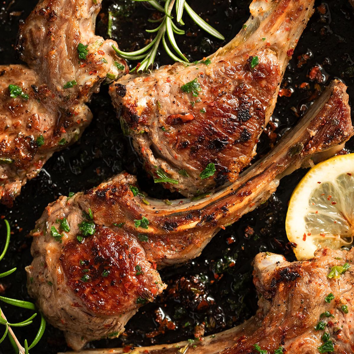 mediterranean lamb chops with rosemary and lemon slices.