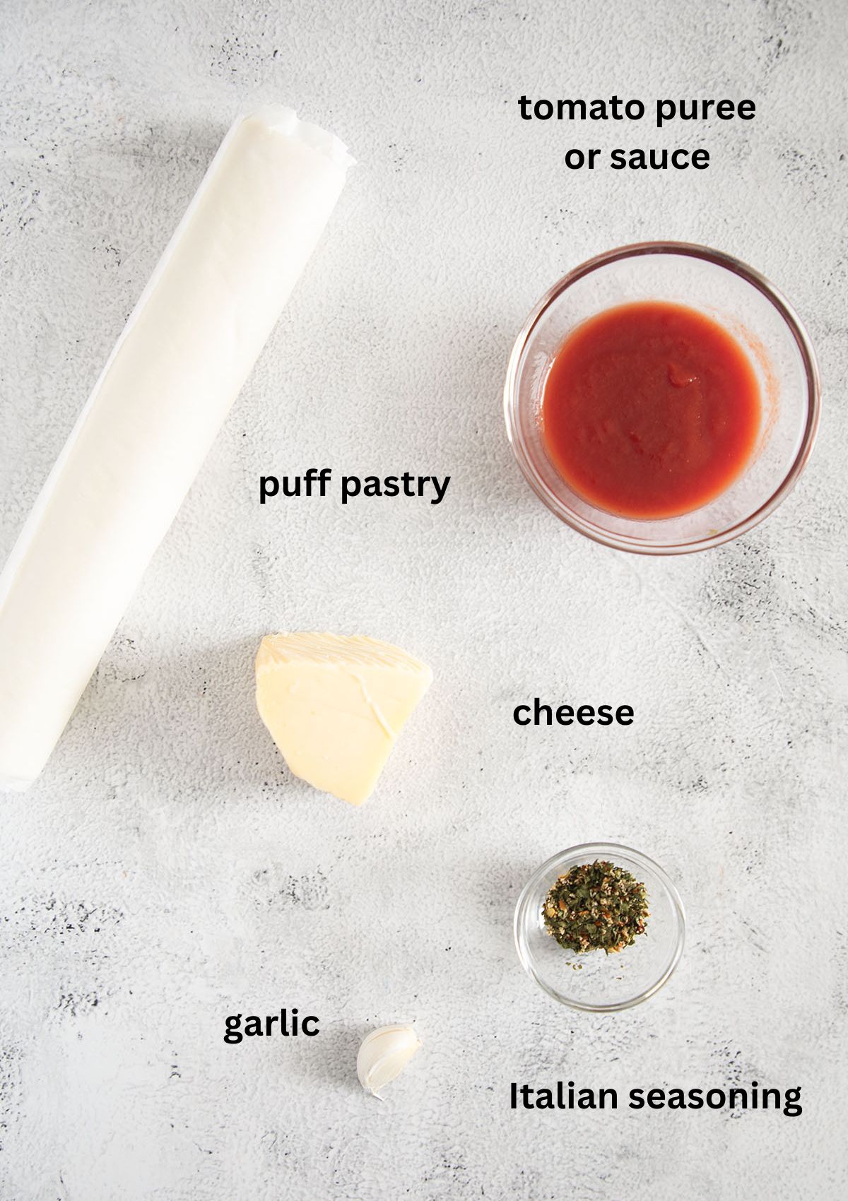 listed ingredients for pinwheels: puff pastry, tomato sauce, cheese, garlic, seasoning.